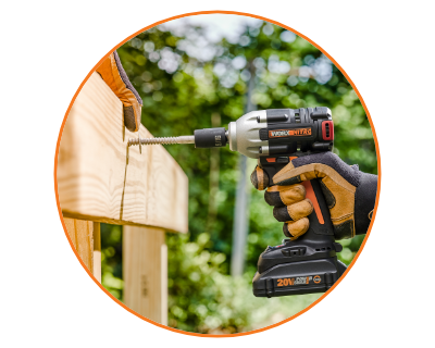 person wearing a glove using the impact wrench to install a wooden fence