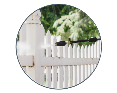 the pressure washer being used on a fence