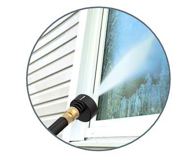 close up of the Hydroshot cleaning a window on a house with white siding