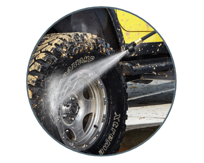 person using the hydroshot to clean a muddy tire