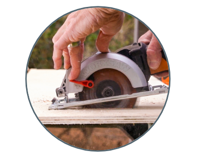 image of a person using the saw to cut a piece of wood