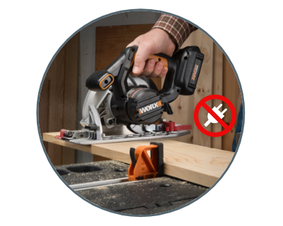 person using the saw to cut a piece of wood with a recepticle cord in a red circle slashed out