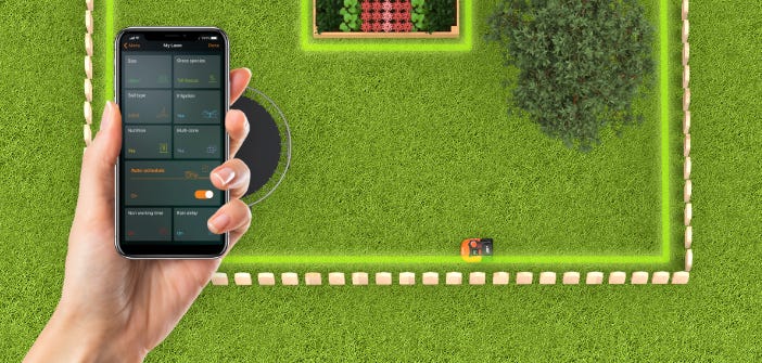 simulated image of a landroid mowing a lawn and a hand holding  a cell phone