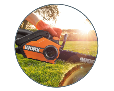 Chainsaw cutting wood in field with sun shining in the background.