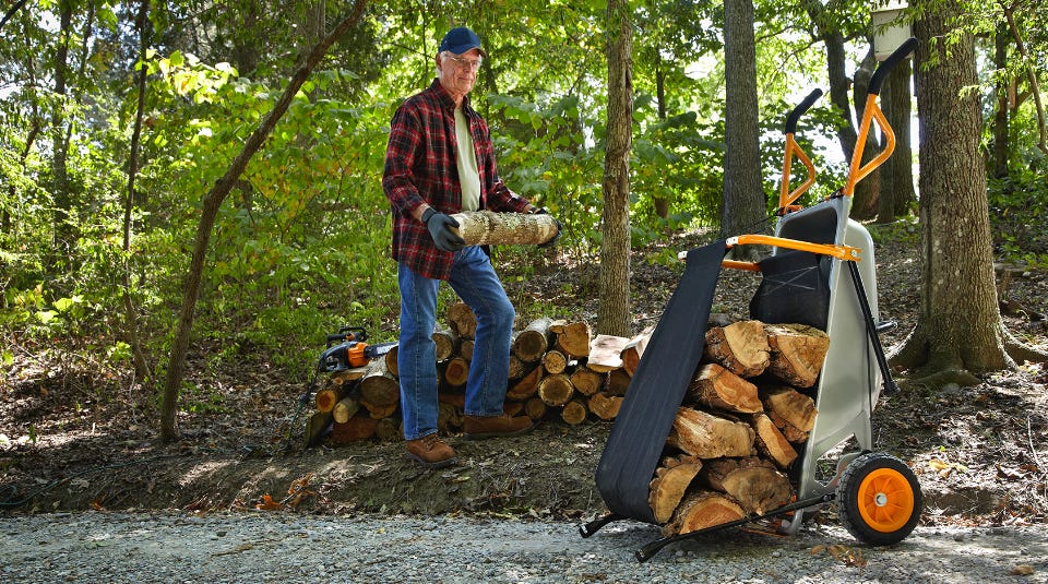 man in the forest loading firewood onto the aerocart