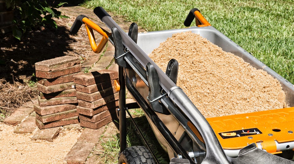 image of the aerocart full of dirt next to a brick path being laid